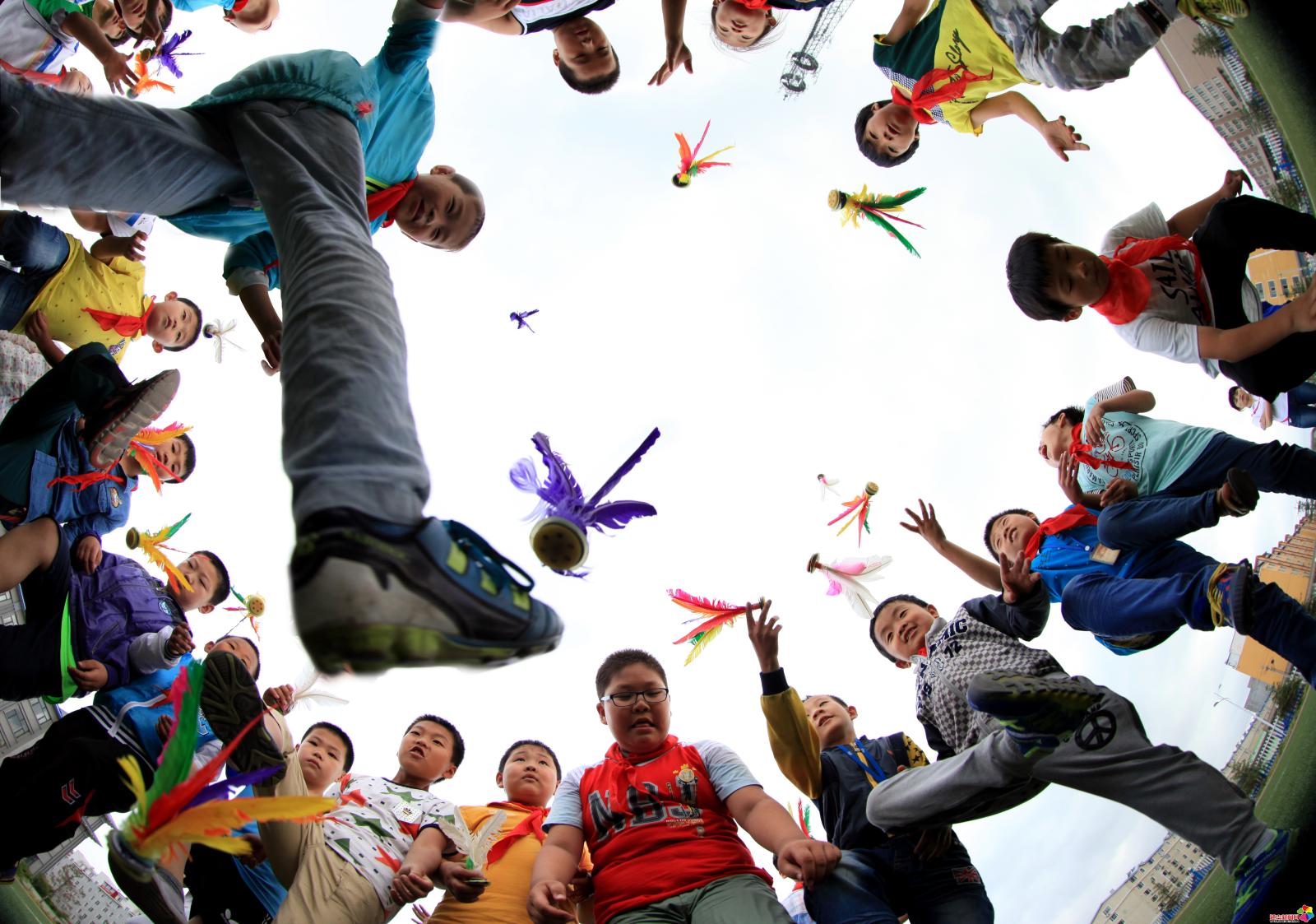 作品：多姿少年  内容：2015年6月18日，延吉市兴安小学学生在课间踢毽子。